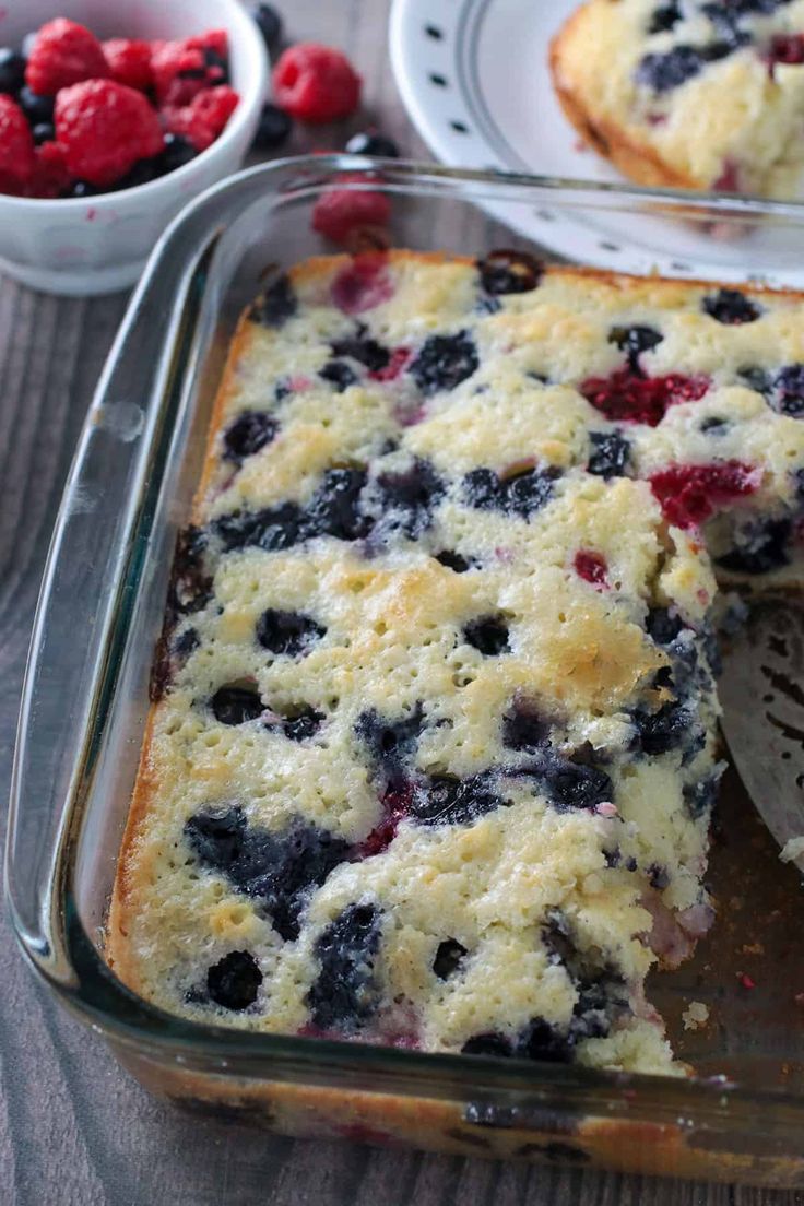 blueberry cobbler in a glass baking dish with one slice cut out