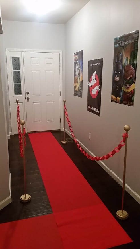 a red carpet is on the floor in front of a white door and some posters