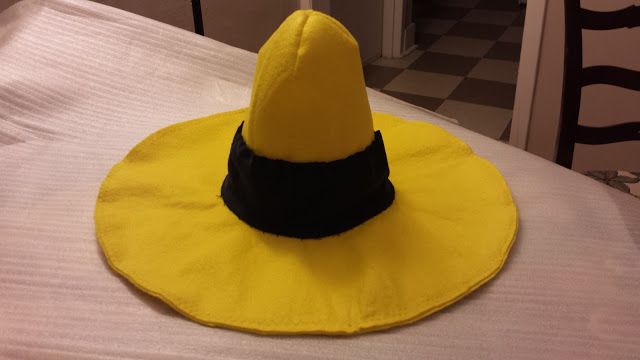 a yellow hat sitting on top of a bed