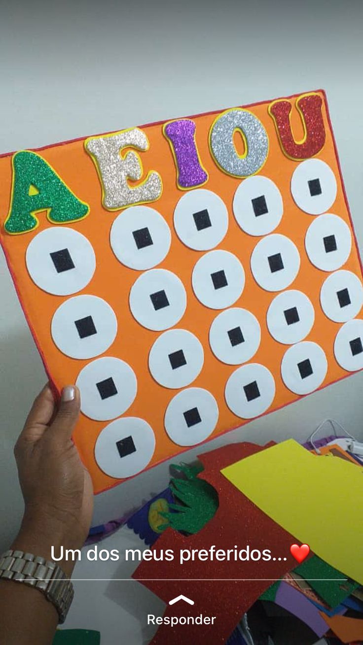 a person holding up an orange and white board with letters on it that spell out the word abco