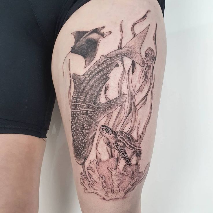 a woman's thigh with an octopus and fish tattoo on it