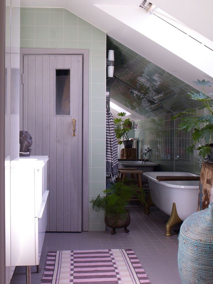 a room with a bathtub, sink and toilet in the corner next to a potted plant