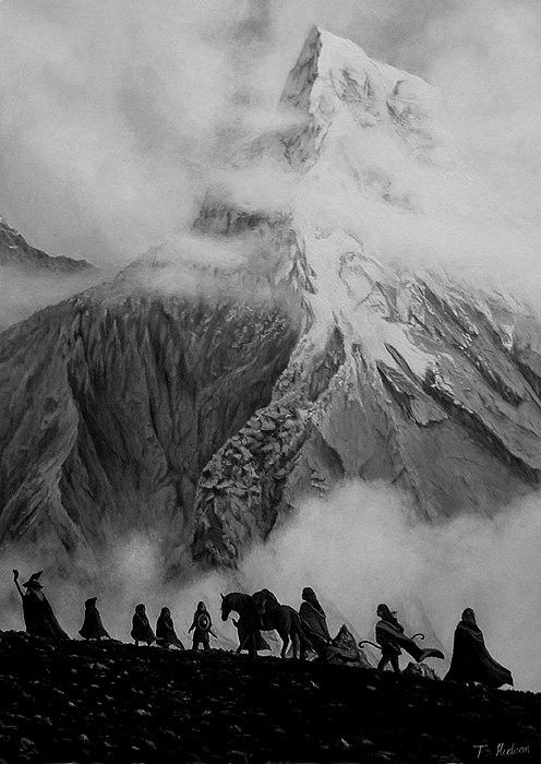 black and white photograph of people riding horses in front of a mountain covered with clouds