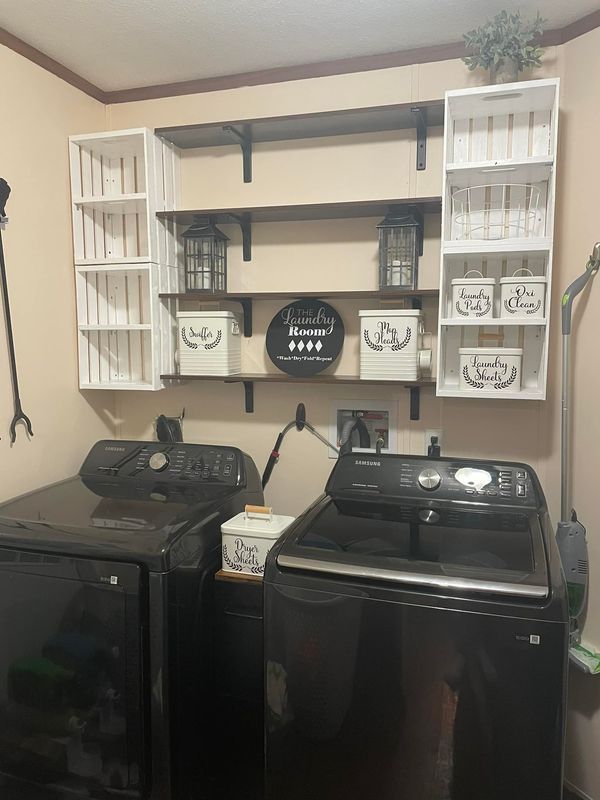 a washer and dryer in a room with shelves on the wall above them