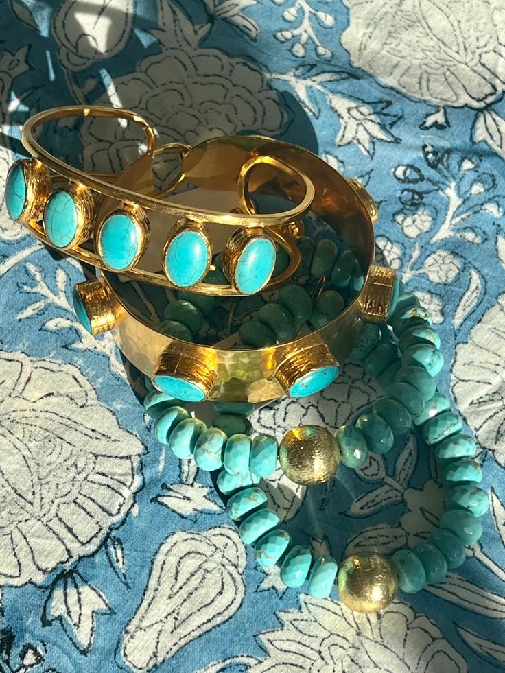 Inspired by ancient artisan jewelry design, the Chakarr Jewelry collection presents the extraordinary Turquoise Byzantine Bracelet, delivering an authentic and unique statement piece. Employing century-old traditions of metal-smithing and casting, this bracelet is meticulously constructed by hand, encasing turquoises, resulting in a truly one-of-a-kind work of art. The brand itself is born from the shared passion of a mother and daughter team, infusing their creations with love, dedication and contemporary elegance with a bohemian vibe. Spiritual Turquoise Bracelet Jewelry, Bohemian Gold Oval Bracelets, Spiritual Turquoise Bangle Jewelry, Artisan Hand Forged Bangle Jewelry, Elegant Patina Bracelets As Gift, Gold Oval Bohemian Bracelets, Turquoise Brass Spiritual Jewelry, Turquoise Artisan Cuff Bracelet With Natural Stones, Handmade Turquoise Jewelry For Ceremonial Occasions