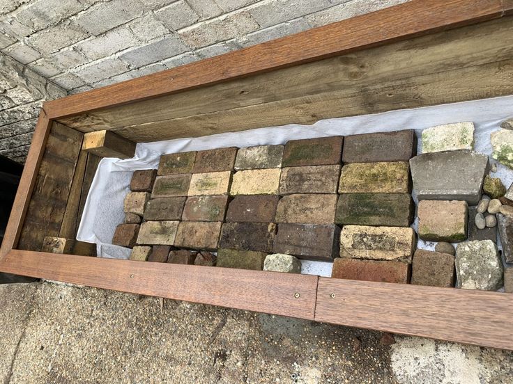 a wooden box filled with lots of different sized rocks