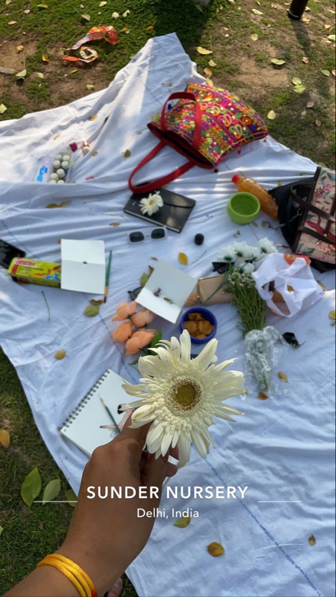 a person holding a flower on top of a white table covered in confetti