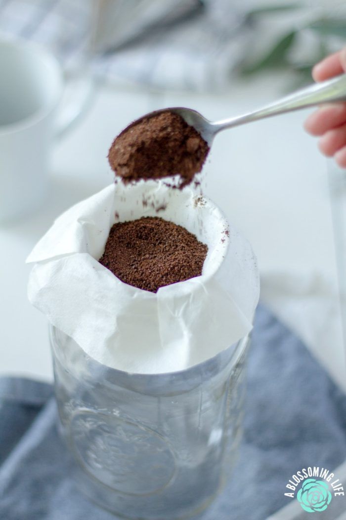 a person scooping ice cream out of a glass jar with a spoon in it