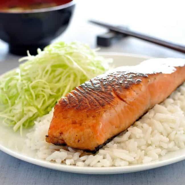 a white plate topped with rice and salmon