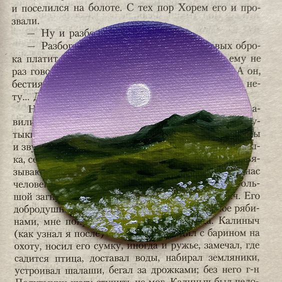 a book with an image of a mountain in the middle and a full moon above it