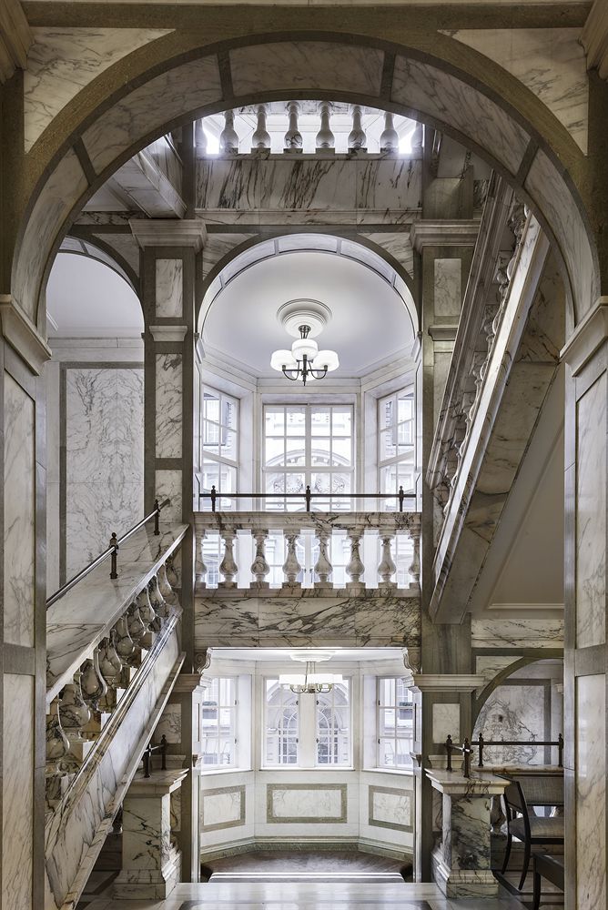 an ornate entry way with marble steps and railings leading up to the second floor