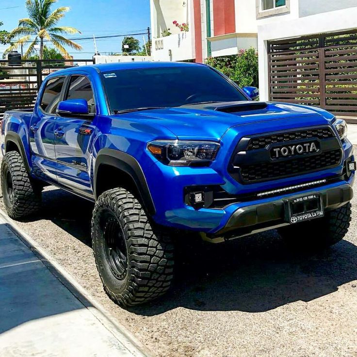 a blue toyota truck parked in front of a house