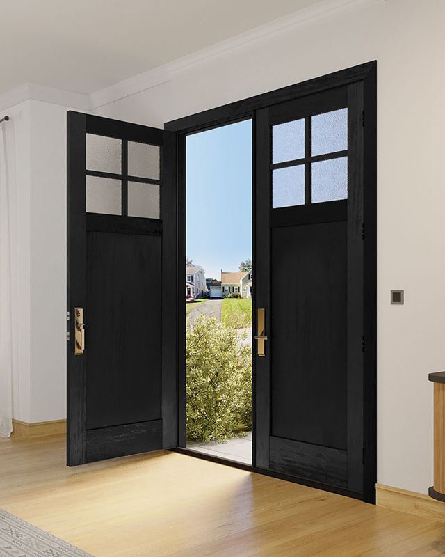 an empty room with black doors and wood floors