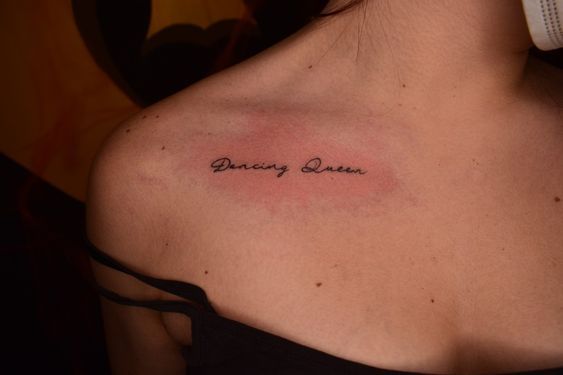 a woman with a tattoo saying dancing queen on her chest and the words dancing queen written in cursive font