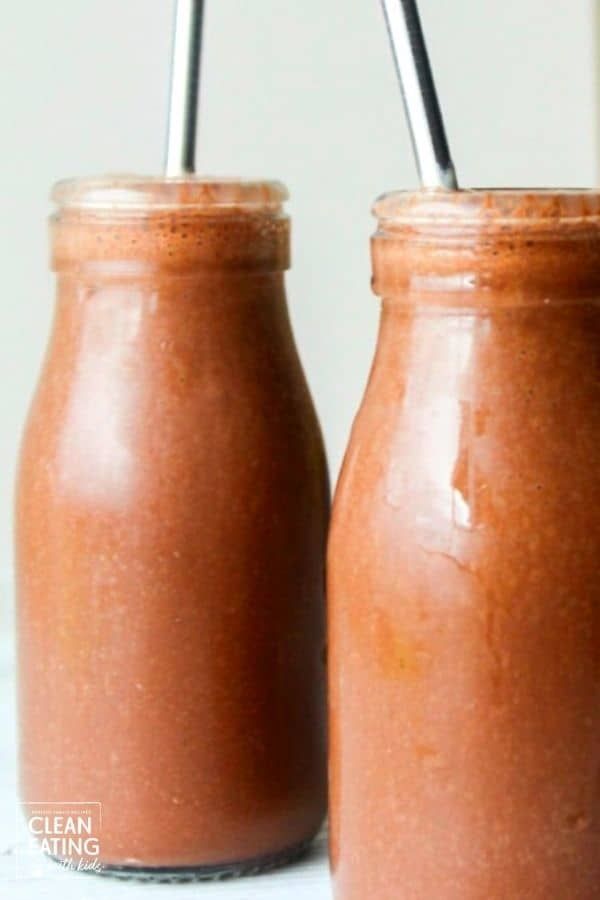 two jars with straws in them sitting next to each other on a white surface