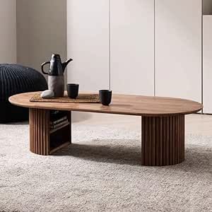 a coffee table with two cups on it in front of a white wall and rug