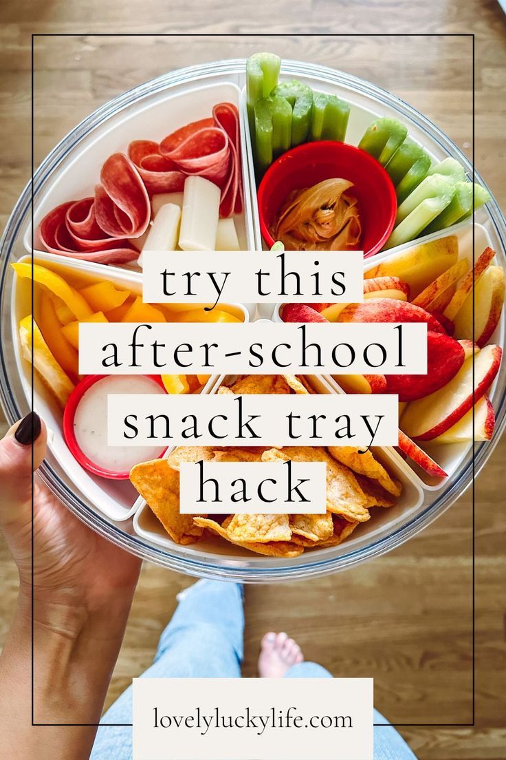 a person holding up a bowl filled with different types of food and the words try this after - school snack tray hack