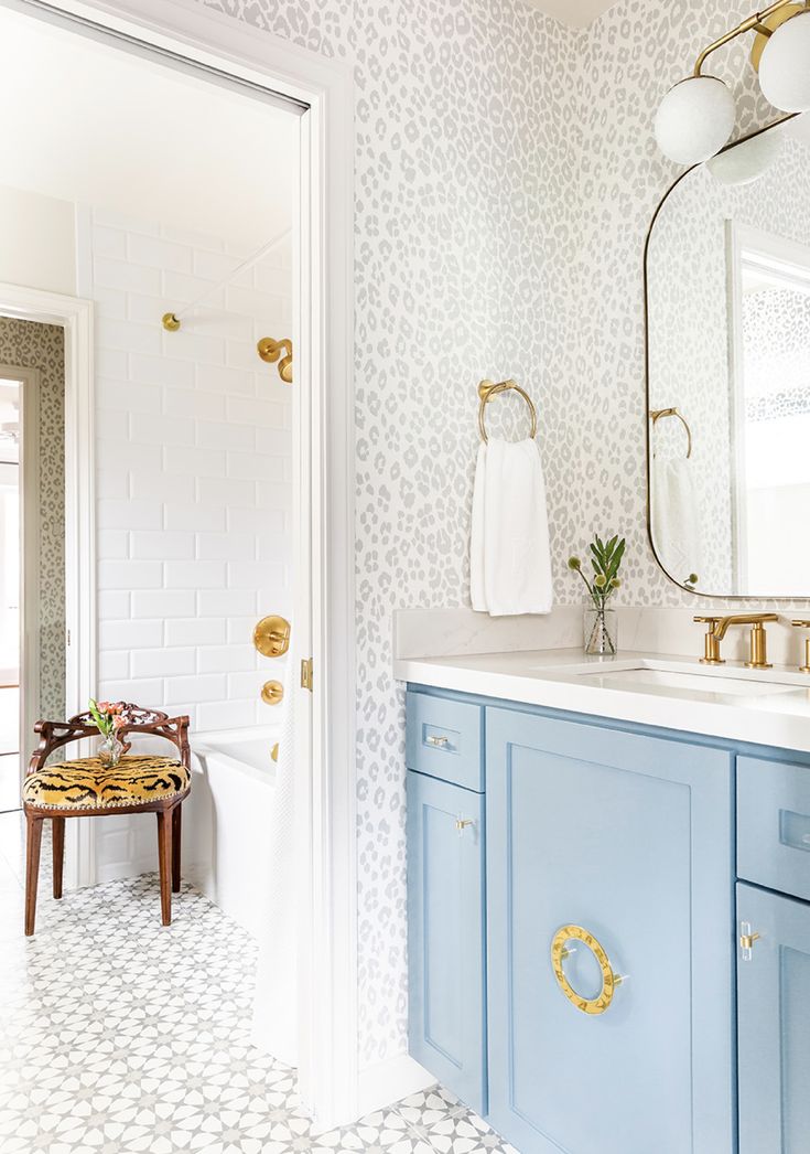 a bathroom with blue cabinets and gold accents