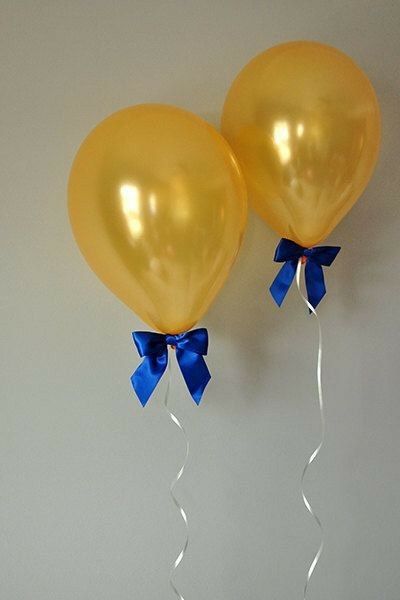 two yellow balloons with blue bows hanging from the ceiling, and an instagram post about them