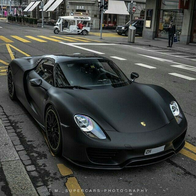 a black sports car is parked on the street