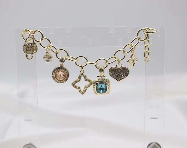 As an expert in the jewelry industry, I can confidently state that our Gold Charm Bracelet is crafted with high-quality materials and exquisite design. Made of genuine gold, this bracelet adds a touch of elegance to any outfit and is sure to become a treasured piece in your collection. Length: 8” adjustable Purse: 0.57”(width); 0.67” (length) Pearl: 0.30” (width); 0.38” (length) Round Light Gold Pendant: 0.66” (width); 1.04” (length) Star: 0.83” (width); 0.86” (length) Light Blue Square Pendant: Round Light, Gold Charm Bracelet, Filigree Earrings, Square Pendant, Blue Square, Diy Sewing Projects, Gold Charm, Tassel Earrings, Exquisite Design