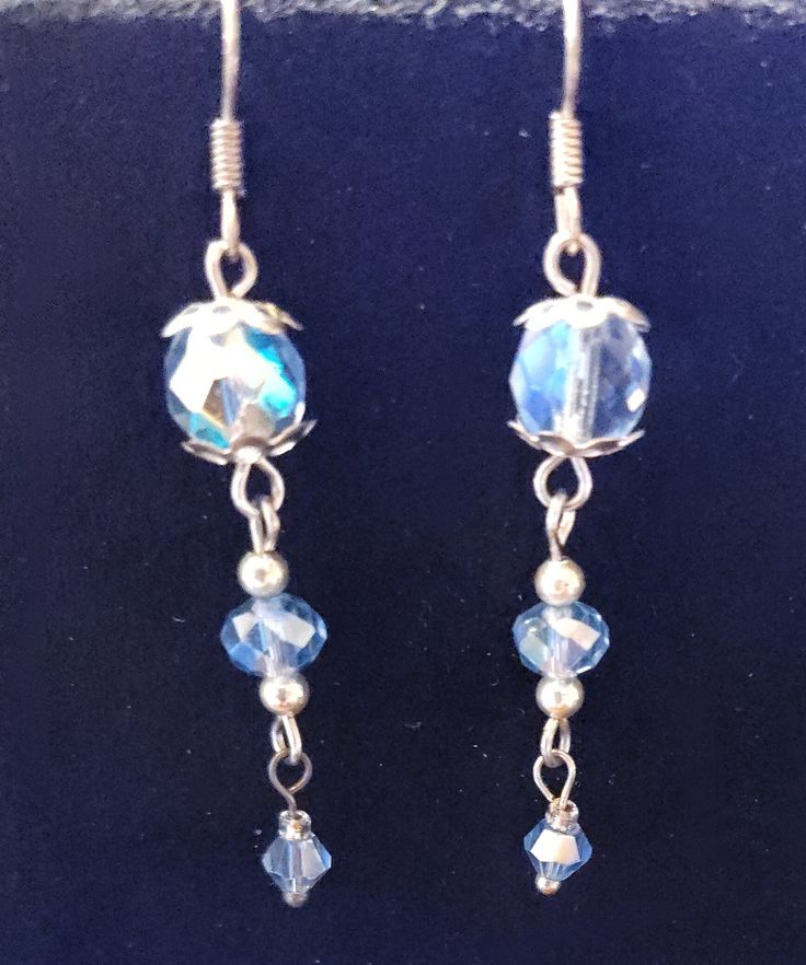 A beautiful pair of silvertone blue crystal earrings. They are silvertone with silver bead caps and spacer beads. As is with all of my jewelry, this is a handmade one-of-a-kind pair of earrings. Thank you for looking and happy shopping. Silver Czech Glass Jewelry With Matching Earrings, Adjustable Metal Earrings With Faceted Beads, Metal Beaded Earrings With Faceted Beads For Gifts, Dangle Earrings With Czech Glass Faceted Beads, Faceted Beads Dangle Crystal Earrings Gift, Dangle Crystal Earrings With Faceted Beads As Gift, Silver Round Bead Costume Earrings, Silver Dangle Crystal Earrings With Faceted Beads, Crystal Beaded Earrings With Faceted Beads For Gift