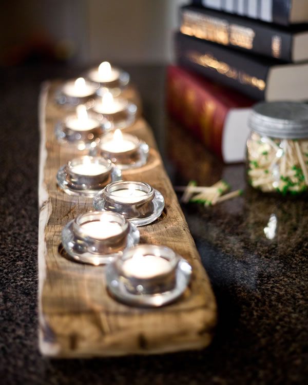 tea lights are lined up on a wooden board with books in the backround