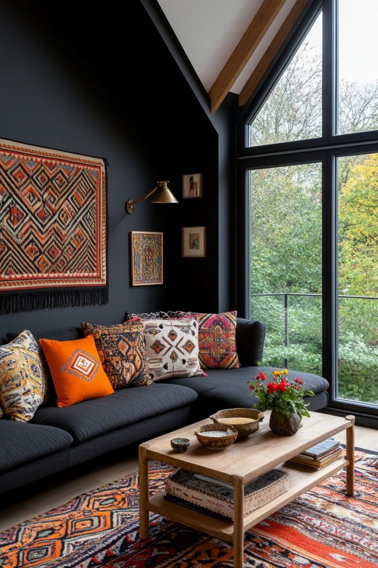 a living room with black walls and colorful rugs on the floor next to a large window