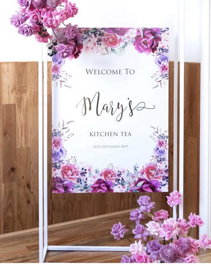 a sign that says welcome to mary's kitchen tea with flowers in front of it