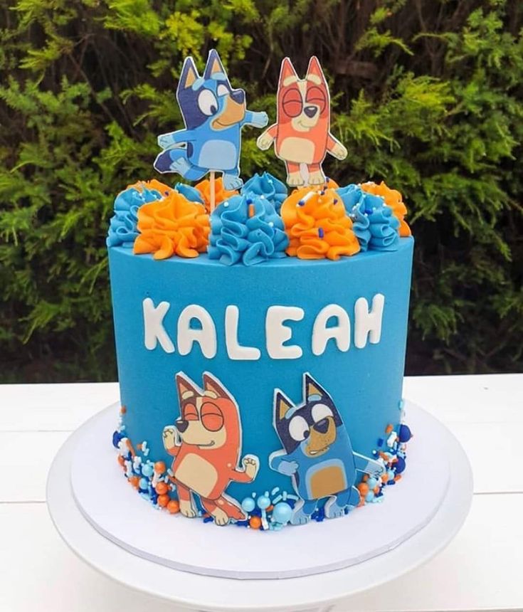 a blue cake with cartoon characters on it