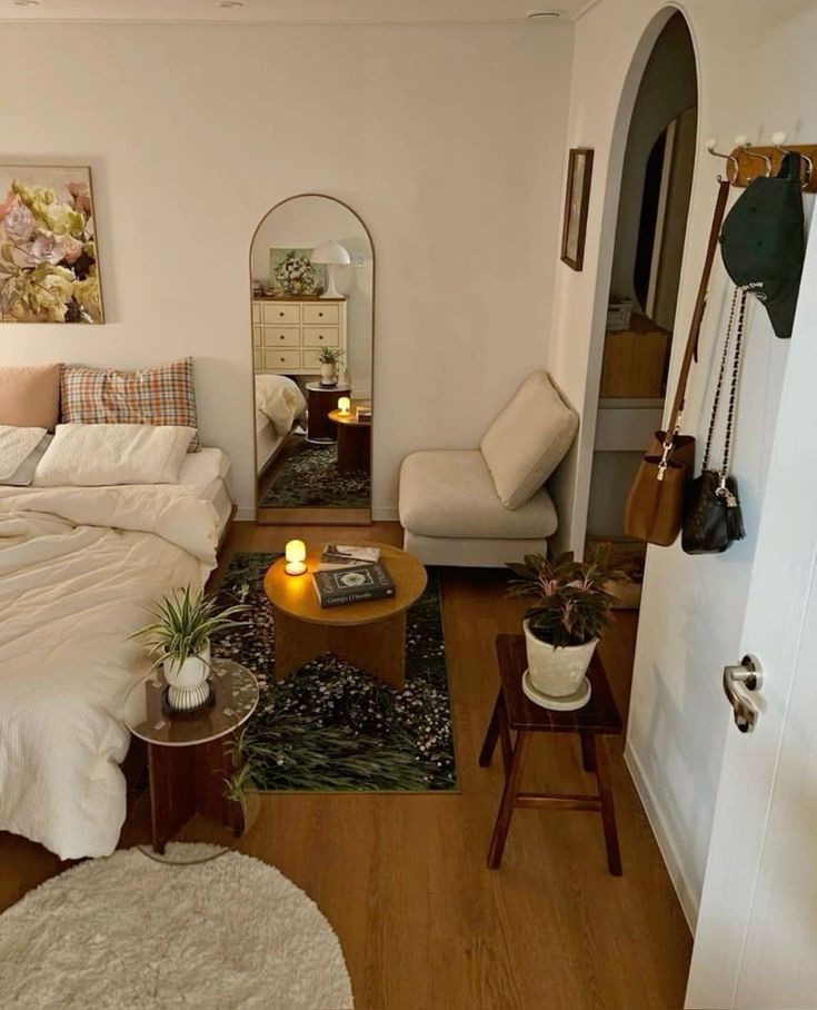 a bed room with a neatly made bed next to a chair and table in it