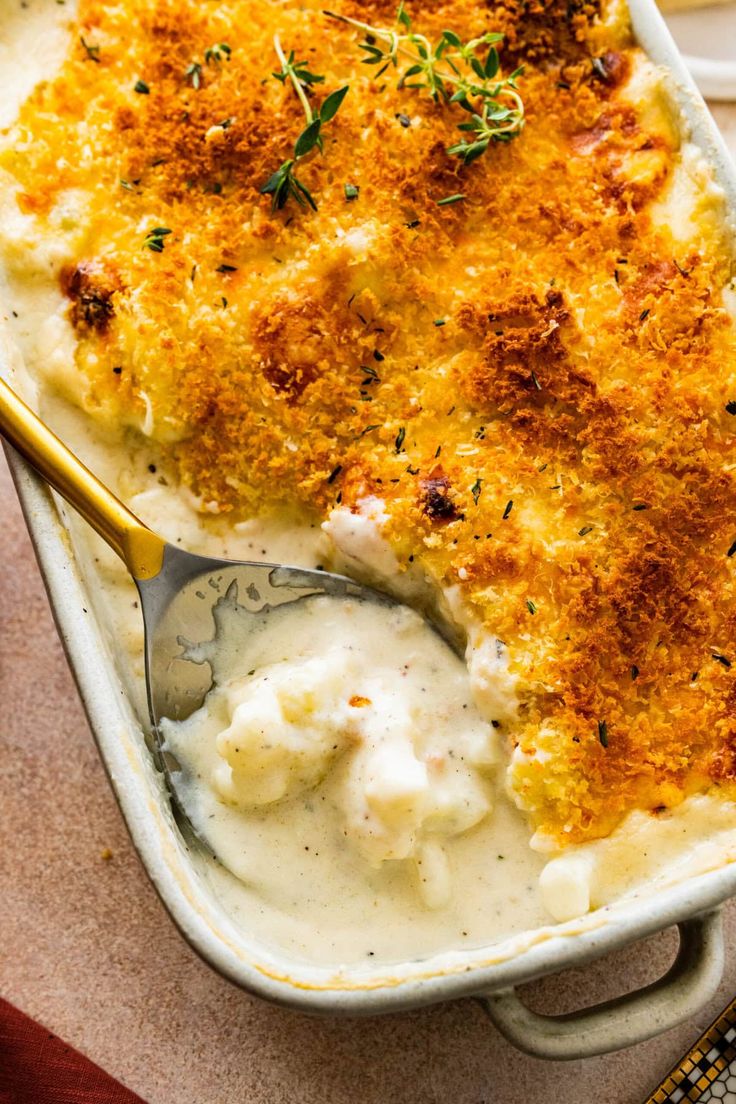 a casserole dish with mashed potatoes and gravy on the side