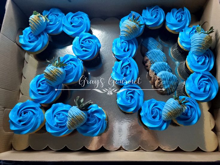 cupcakes with blue frosting in a box