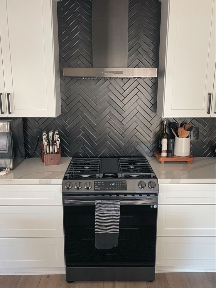 Matte black herringbone kitchen backsplash, white shaker cabinets. White Cupboards Black Backsplash, Black Stacked Backsplash, Black Backsplash Wood Countertop, Black Matte Backsplash Kitchen, Black Backsplash Black Grout, Matte Black Herringbone Backsplash, White Subway Tile Kitchen Backsplash With Black Accent, Black Tile Backsplash Kitchen White Cabinets, Black Matte Backsplash