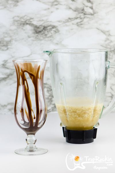 two blenders sitting next to each other on top of a white countertop, one filled with liquid and the other empty