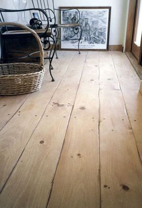 an empty room with wooden floors and pictures on the wall, including a wicker basket