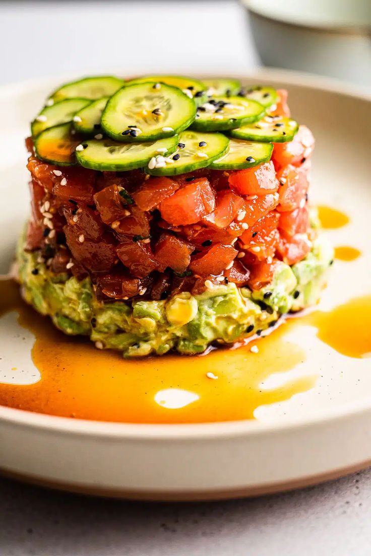 a white plate topped with cucumber and tomato