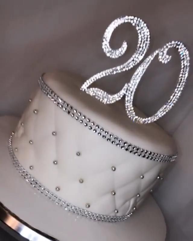 a white hat with the number twenty nine on it is adorned with silver chains and beads