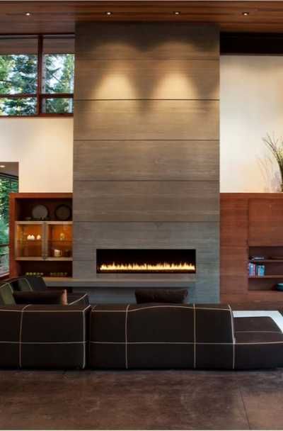 a modern living room with a fireplace in the center