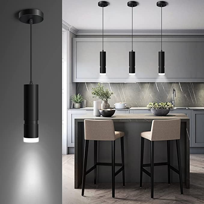 a kitchen with two stools next to a counter and some lights hanging from the ceiling