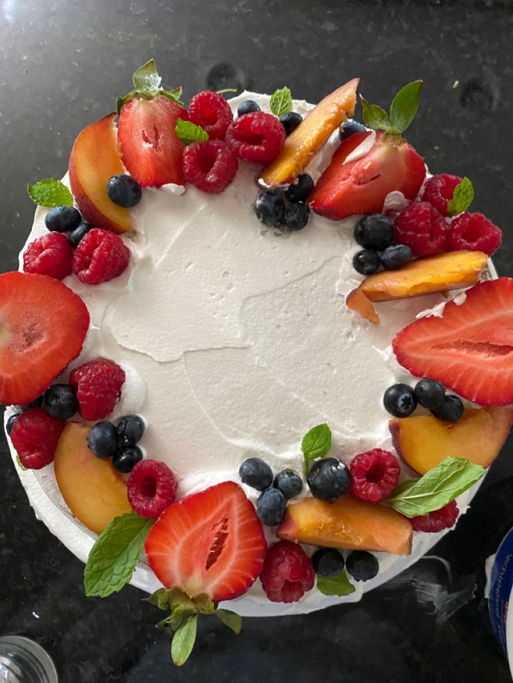 a cake with fruit on it sitting on top of a table