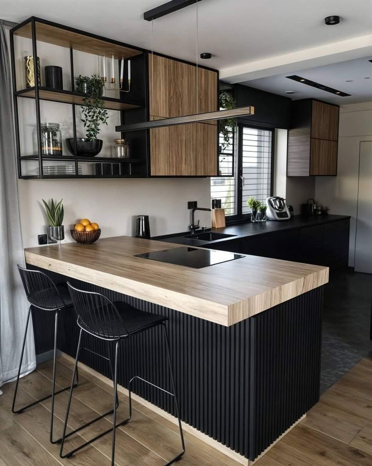 a kitchen with black cabinets and wooden counter tops, two bar stools in front of the island