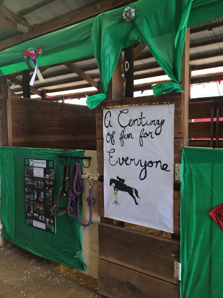 a sign that is on the side of a wooden structure with green tarp covering it