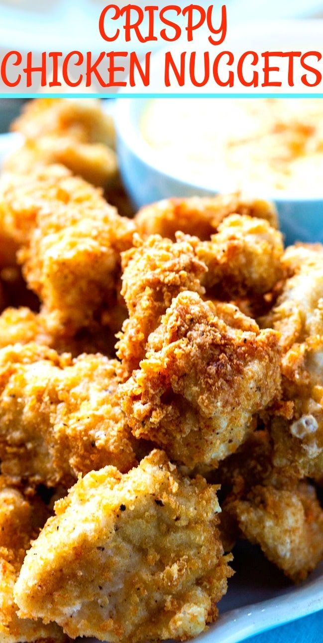 crispy chicken nuggets on a plate with ranch dips in the background