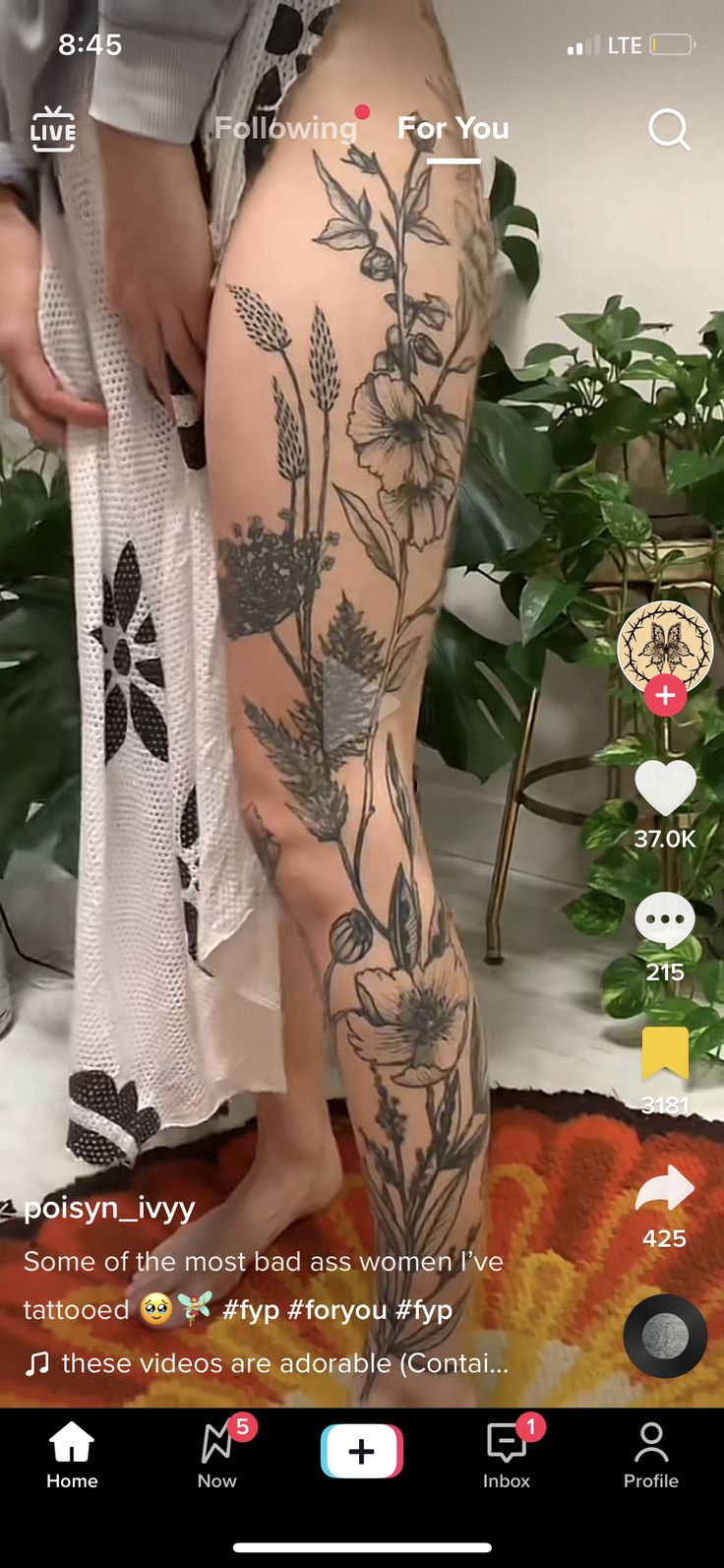 a woman's legs with tattoos on them and flowers in the bottom right leg