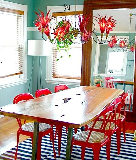 a dining room with red chairs and a wooden table