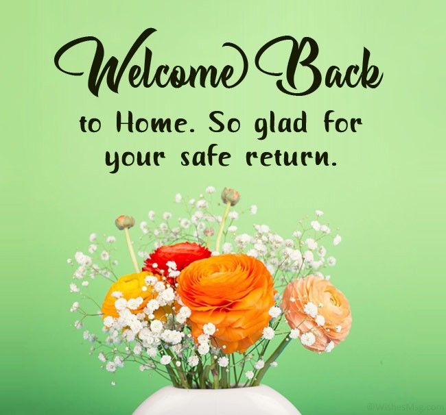 a vase filled with flowers sitting on top of a table next to a sign that says welcome back to home so glad for your safe return