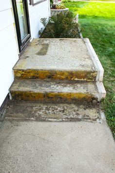 concrete steps leading up to a house with grass in the background