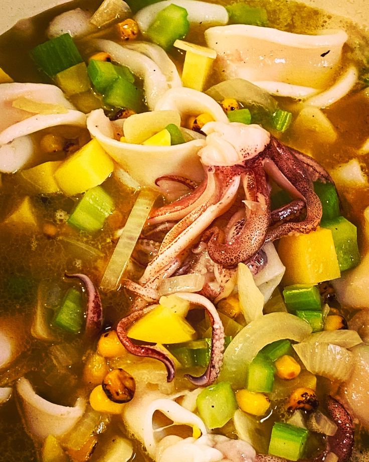 an octopus and vegetable soup in a bowl