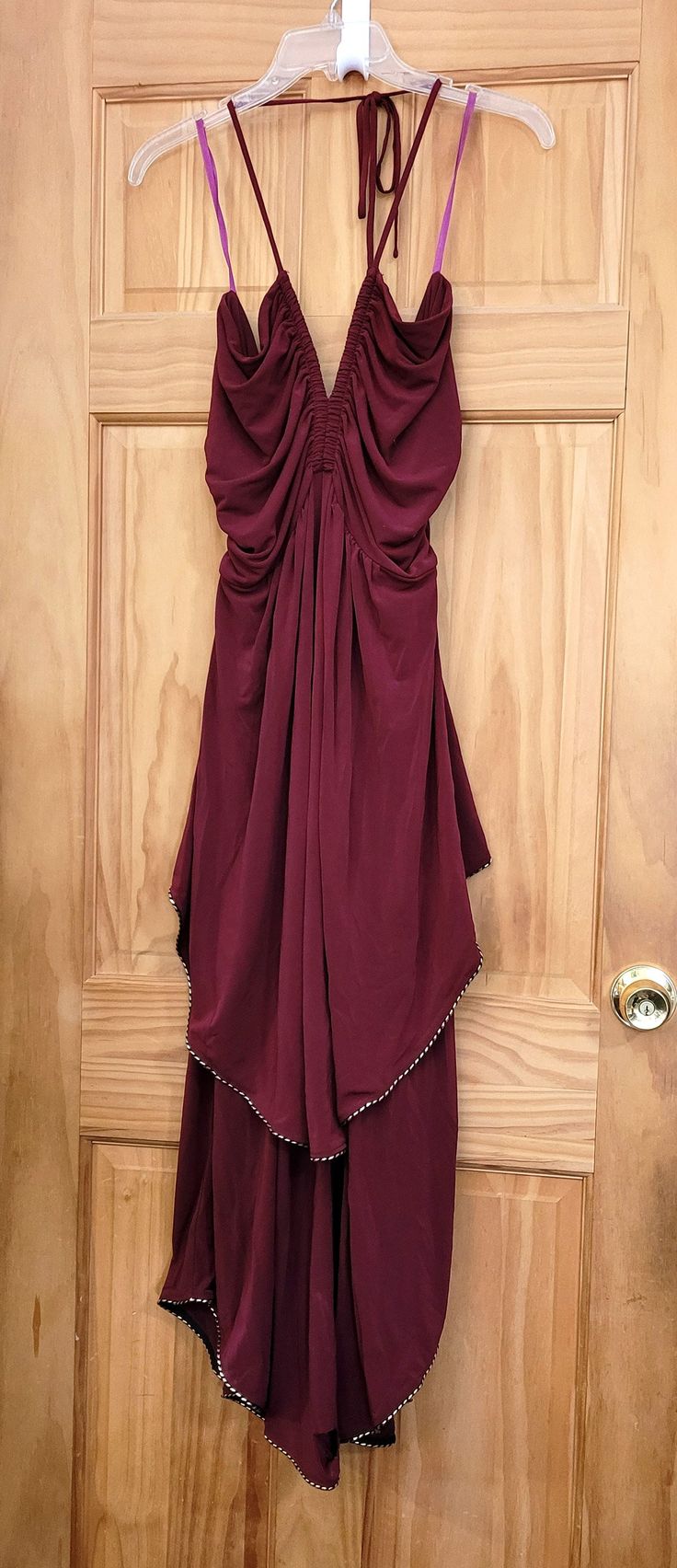 This beautiful luxurious draped jersey halter maxi dress has boning and ruching at the v neck in front and ruching at the waist. Dress has a slightly gathered double layer skirt at bottom with metallic black and gold lame piping at asymmetrical peplum and at rounded shirttail hem. Gathering and exposed with gold zip closure on the back. Spaghetti straps tie to the back at the nape of the neck. NOTE* - Dress has been worn once by Lexie and is new with tags. Dress has a slight tear on the front of Party Maxi Dress With Ruched Sides And Draped Shape, Evening Halter Neck Ruched Maxi Dress, Draped Maxi Dress With Ruched Sides For Party, Ruched Draped Halter Dress For Evening, Draped Skirt With Ruched Sides For Evening, Draped Maxi Dress For Prom, Draped Maxi Dress With Ruched Bodice For Dinner, Elegant Party Maxi Dress With Gathered Waist, Elegant Maxi Dress With Gathered Waist For Party